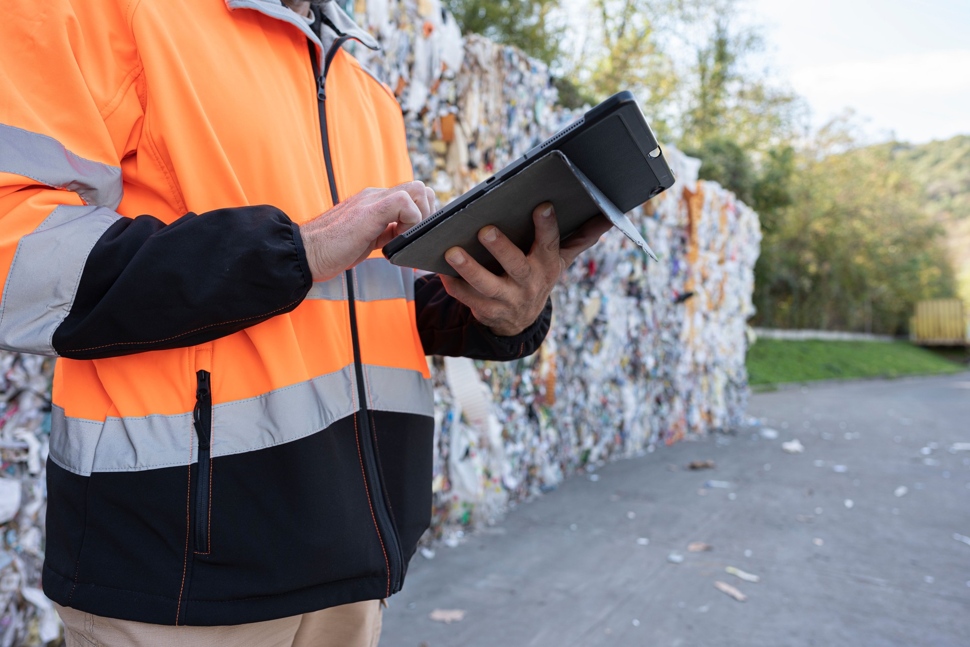 Worker Inspects Bales of Sorted Recycled Materials in Factory